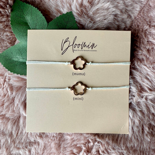 Pair of star-shaped bracelets on a 'Bloomin' branded card with leaves on a fluffy pink surface